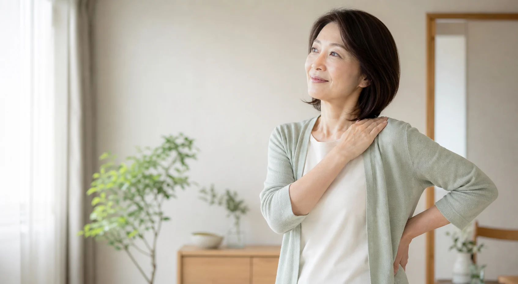 肩と腰のこわばりが気になり、体に手を添える女性